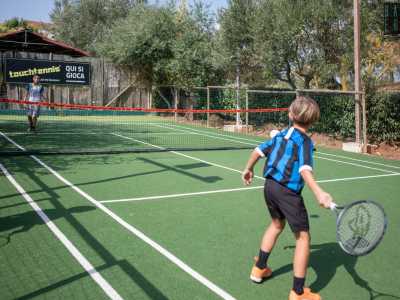 Sul terreno di gioco troviamo Luca, di 8 anni, figlio di Massimiliano, che si sta scontrando con un coetaneo al primo incontro di touchtennis